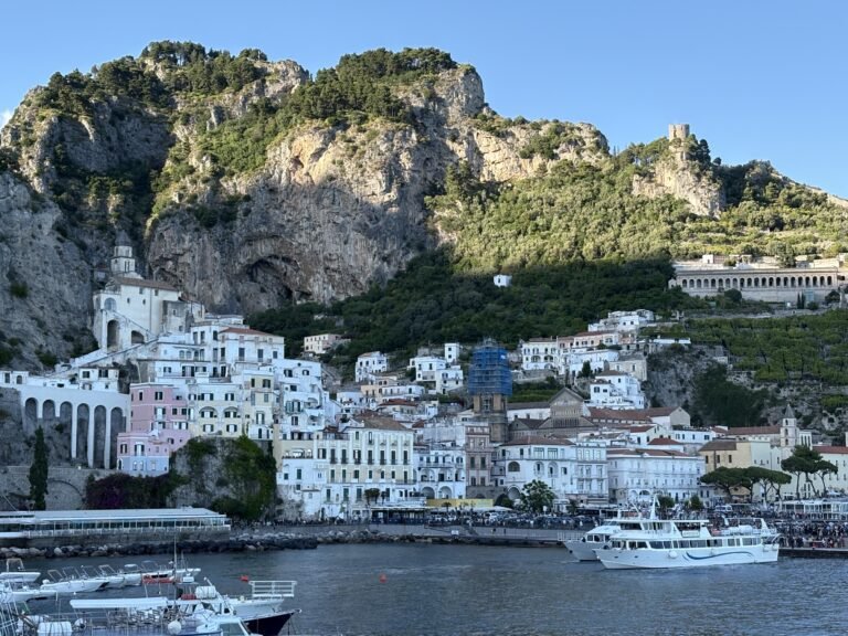 Amalfi Town and harbour with passenger ferries below the mountains.
