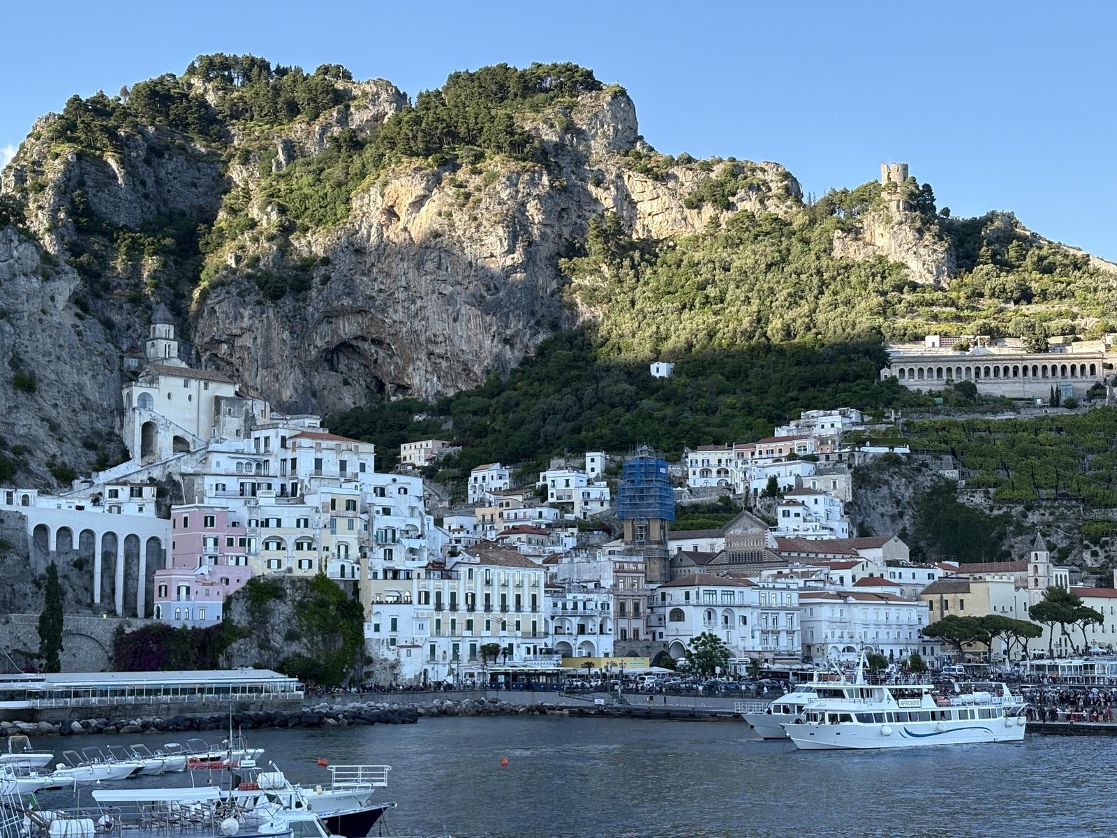 Amalfi Town and harbour with passenger ferries below the mountains.