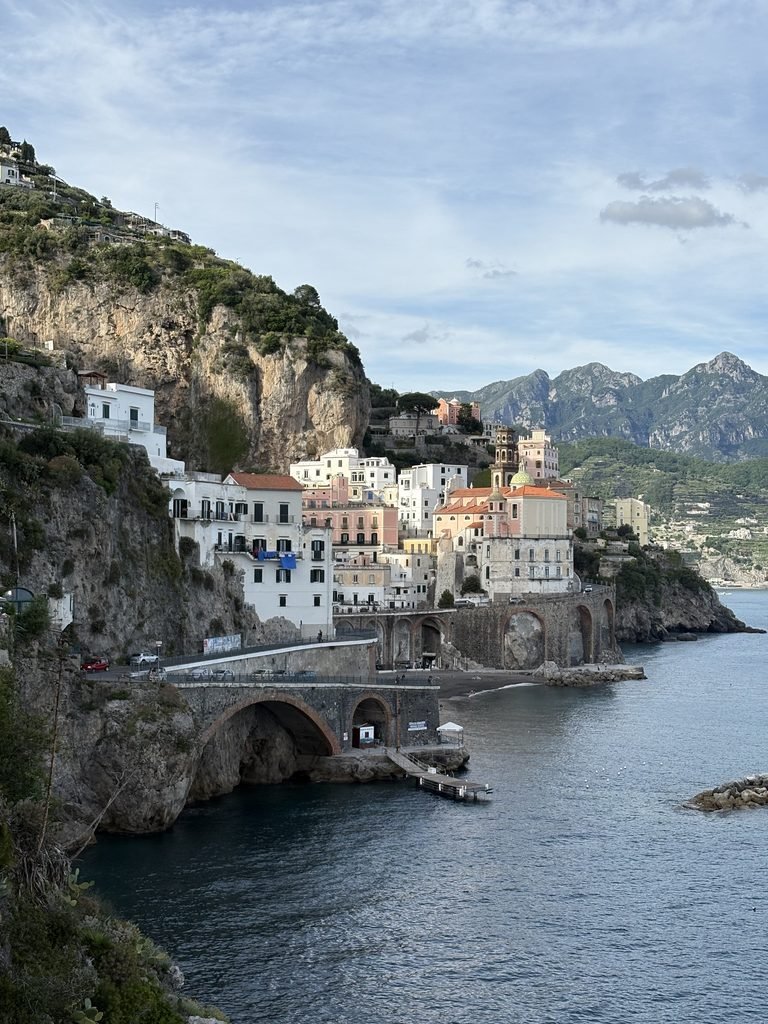Atrani on the Amalfi Coast, with pastel buildings clustered between steep cliffs.