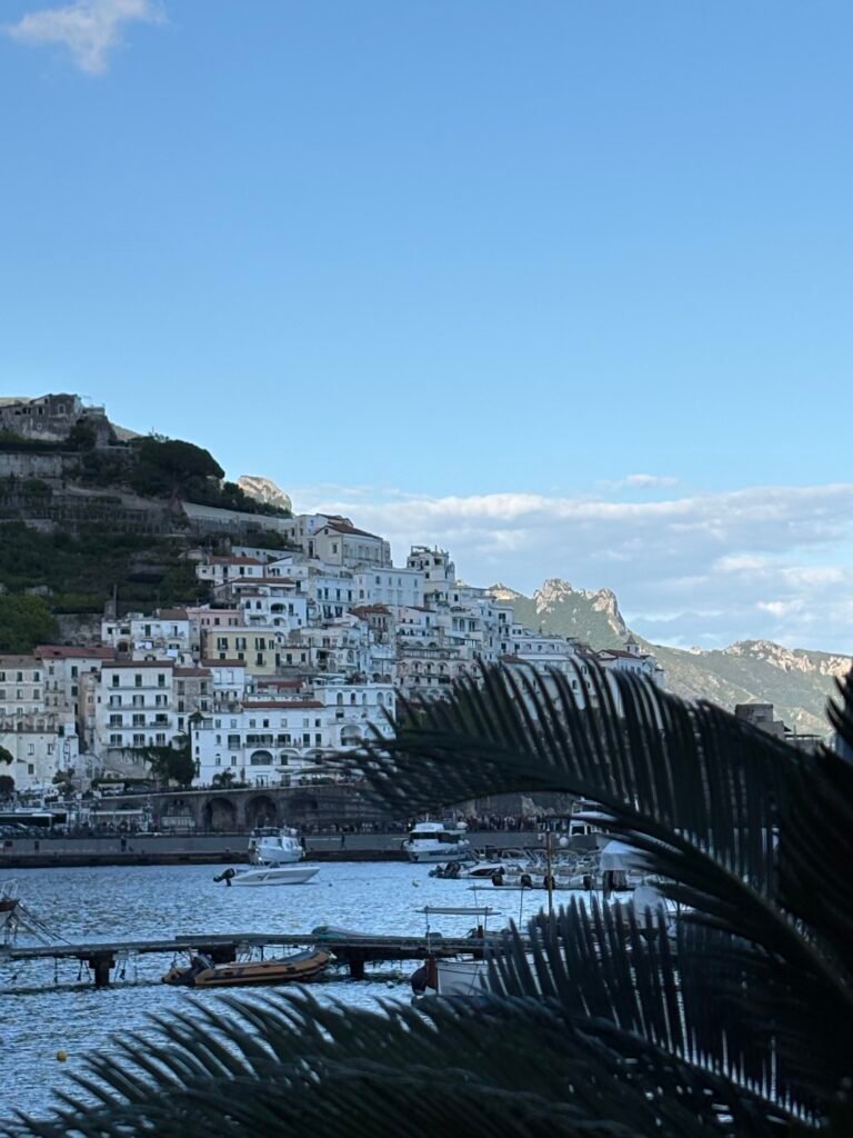 Amalfi harbour with boats and the town rising behind the waterfront.