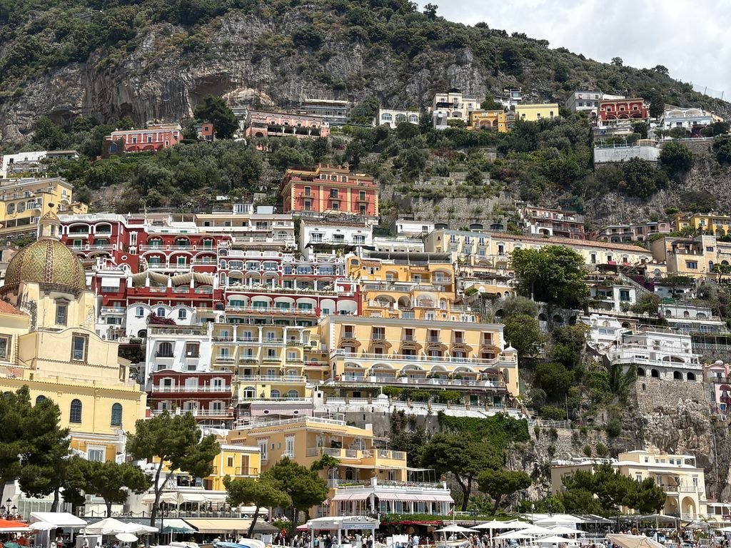 View of Positano from the waterfront, with colourful buildings climbing the steep hillside.