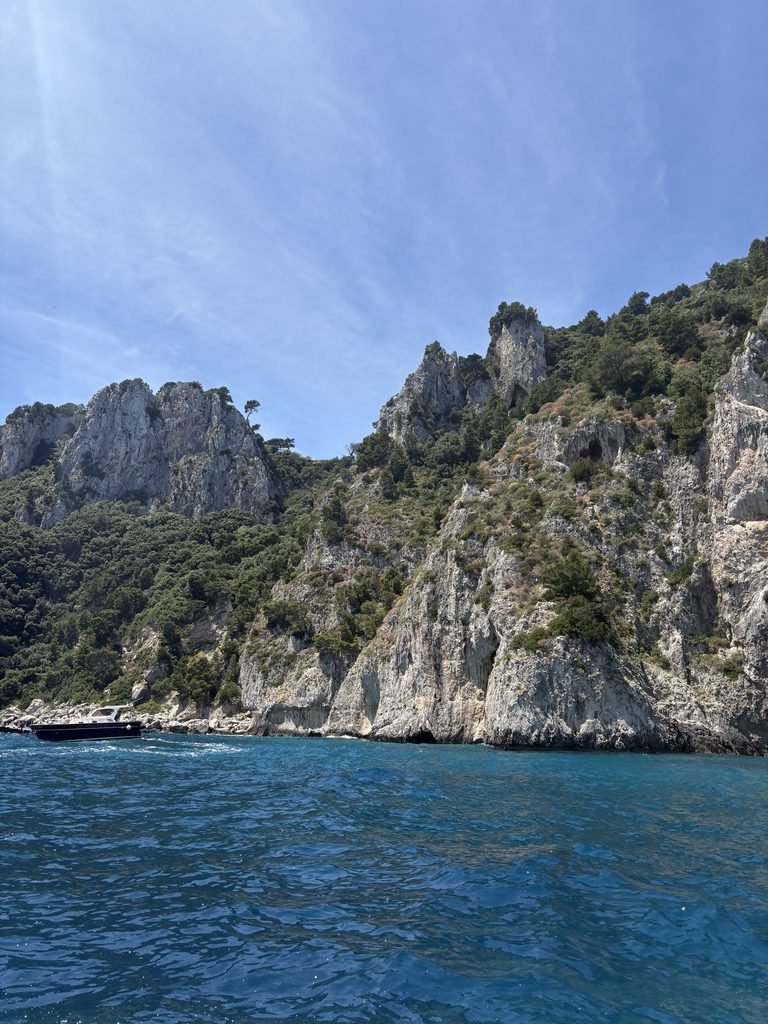 Blue water beside large rocky cliffs near a swimming stop off Capri.